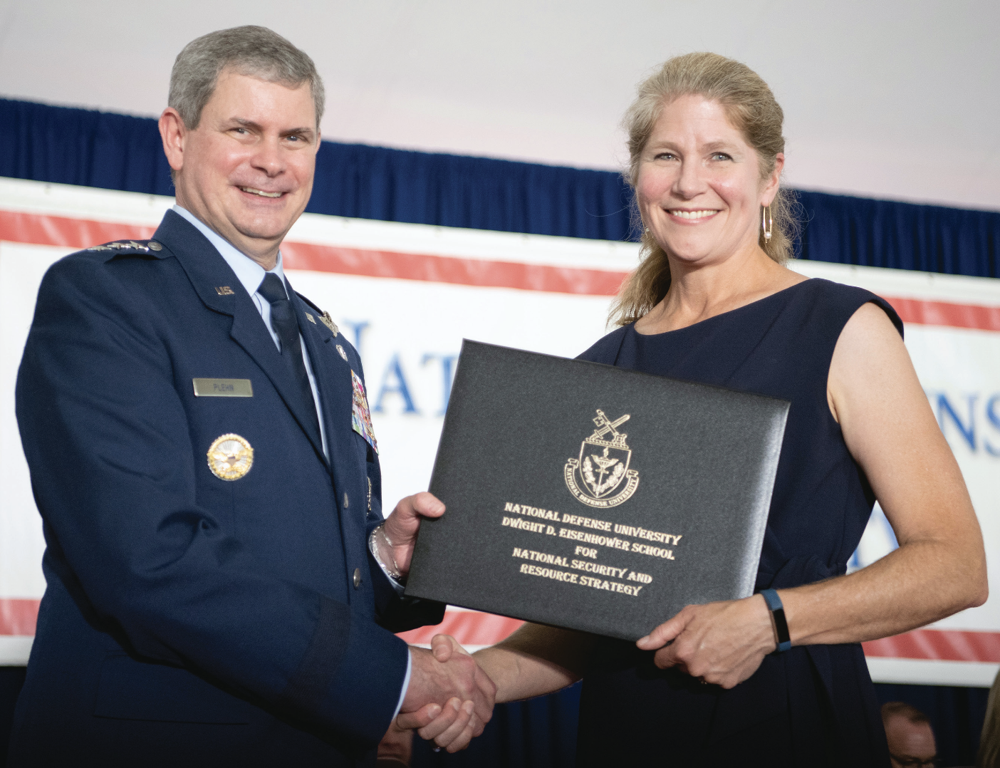 Then National Defense University President Lieutenant General Michael Plehn congratulates graduate from Dwight D. Eisenhower School forNational Security and Resource Strategy during graduation ceremony on parade grounds in front of National War College, Fort Lesley J. McNair,Washington, DC, June 8, 2022 (NDU Audio Visual)